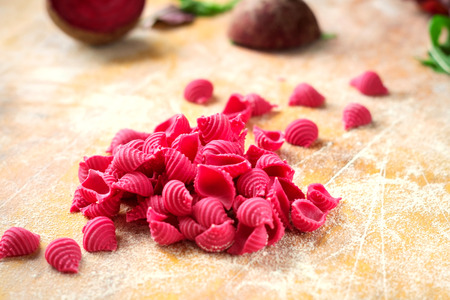 Hand made beetroot pasta on a wooden table. Raw purple Conchiglieの写真素材
