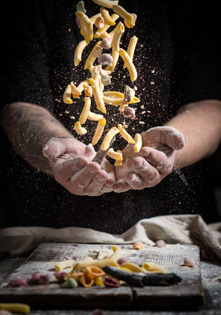 close hand make pasta toss f on a black background before cooking the dishの写真素材