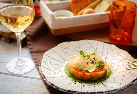 salmon tartar on white plate, serving at the restaurantの写真素材