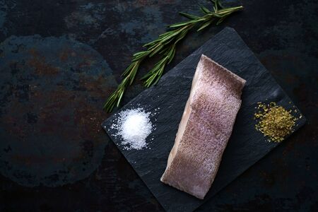fresh steak raw fish halibut on the stone with the salt and herbs on steel backgroundの写真素材