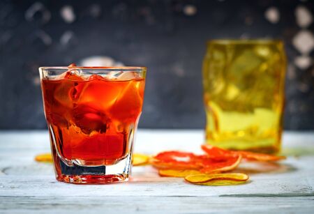 Negroni cocktail in glass with orange and lemon. Alcoholic drink with rum and vermouth on white wooden background.の写真素材