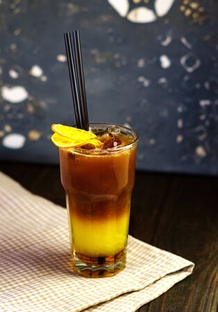 Cold coffee in a glass with orange flavorの写真素材