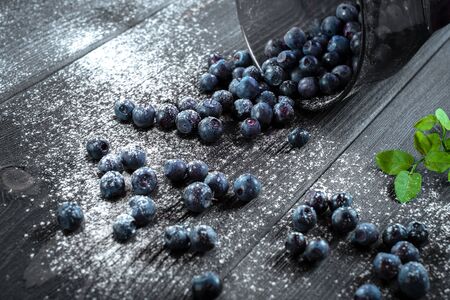 Organic fresh blueberries in glass Cup on black wooden background. Healthy home nutritionの写真素材