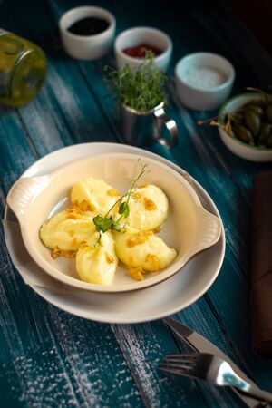 Mashed potatoes serving in a white plate on a blue wooden backgroundの写真素材