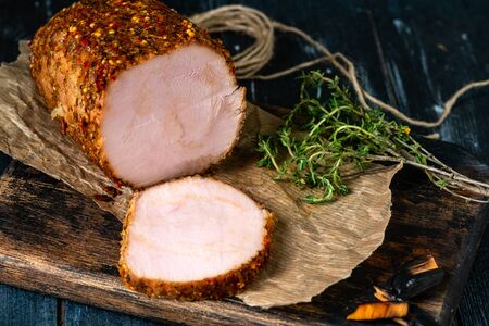 Smoked Turkey breast roll baked with spices and sliced on a wooden Board, rustic styleの写真素材