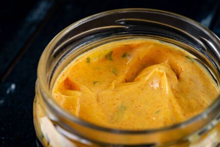 Homemade organic Dijon mustard on a dark wooden background, souce for meat dishes