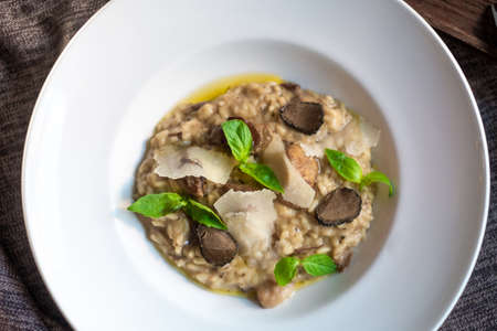 Risotto with mushrooms, Parmesan cheese, Basil and truffle on a white plate, Italian dish, top viewの写真素材