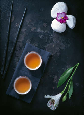 Asian tea ceremony. Chinese ceramic tea cups on stone dark background