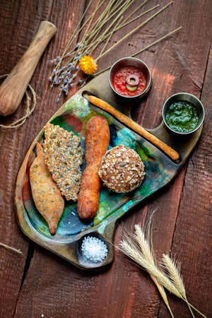 Various home-made breads and pastries on a tray on a wooden background, rustic styleの写真素材