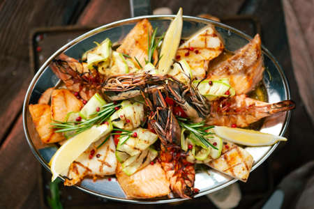 Grilled Mixed Seafoods set in metal plate with shrimp, salmon, squid and perch.の写真素材