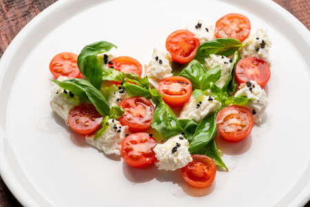 Ingredients for Caprese salad in the form of a heart. Symbol of love for Italian food