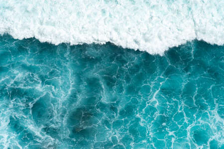 Texture Light blue surface of raging sea water with white foam and wave patternの写真素材