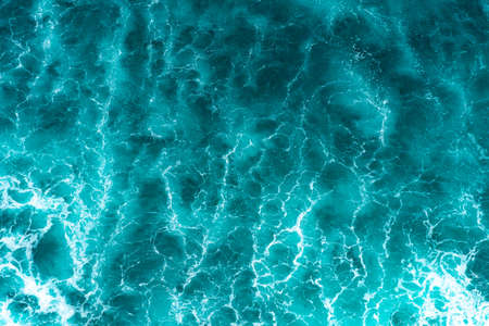 Texture Light blue surface of raging sea water with white foam and wave patternの写真素材