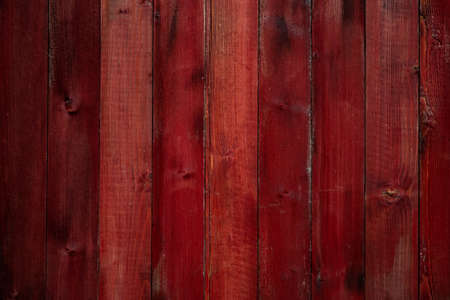 Aged red wooden wall with cracks and scuffsの写真素材