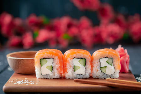 Set Philadelphia sushi roll with Sakura on a wooden Board close-Up, selective focusの写真素材
