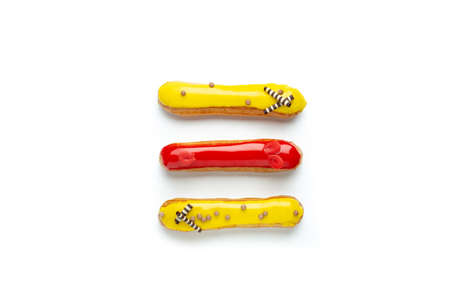 French glazed eclairs with lemon and strawberry cream, sweet dessert on white, top viewの写真素材