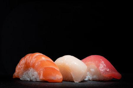 Japanese sushi set with salmon, tuna and perch on a black stone background, copy spaceの写真素材