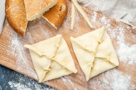 Uncooked Pie with cheese inside on a wooden Board-Khachapuri national Georgian dishの写真素材