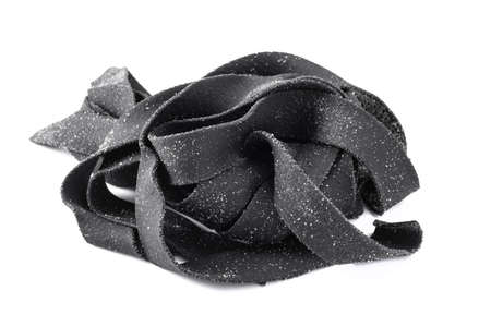 Squid ink raw tagliatelle pasta isolated on a white backgroundの写真素材