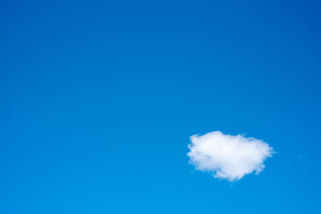 Clear blue sky on a summer day with one cloudの写真素材