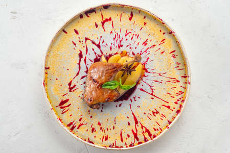 Roast Goose leg with pear and sweet sauce on a plateの写真素材