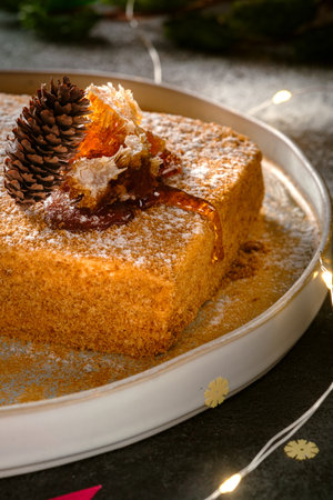 honey cake with honeycombs and christmas decorations and lights. sweet dessert for the holiday, close upの写真素材