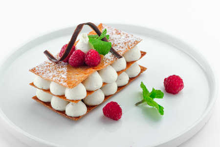 raspberry mille feuille dessert with whipped sour cream on a white plateの写真素材