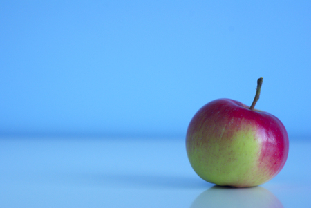 Red green fruit fresh apple on blue background with copy-spaceの写真素材