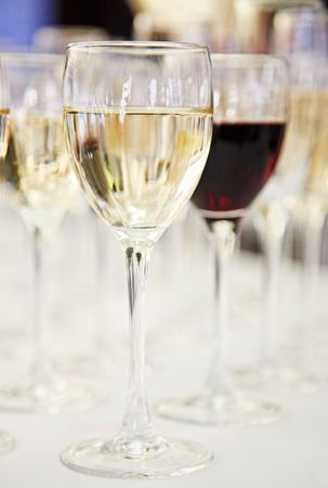 White and red wine glasses on blurred background with shallow depth of field.の写真素材