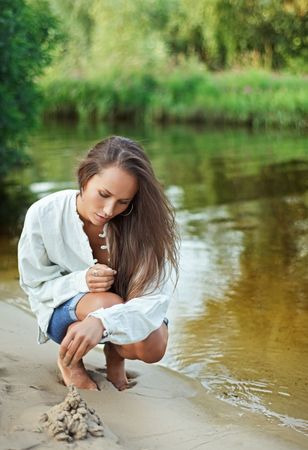 Beautiful young woman bilding sand castleの写真素材