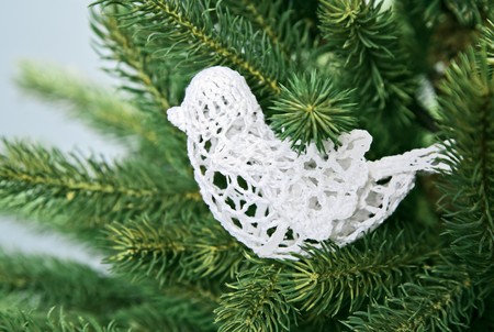 White sewing bird Christmas decoration on green spruce branchの写真素材