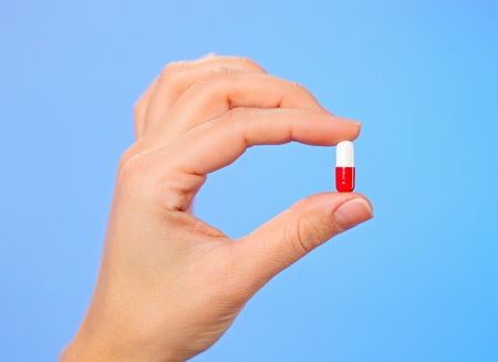 Red and white bolus (capsule) in doctor hand, macro viewの写真素材