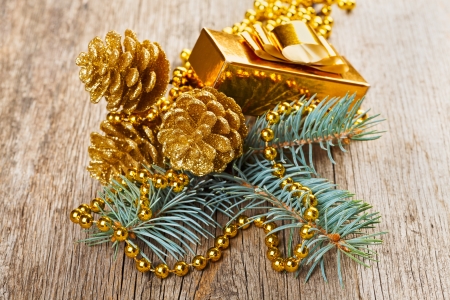 Christmas golden decorations on pine branch on wooden backgroundの写真素材