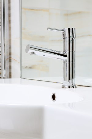 Modern metal faucet on white ceramic wash stand, interior detailの写真素材