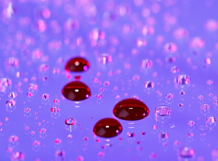 Blood drop on abstract translucent water background, macro viewの写真素材