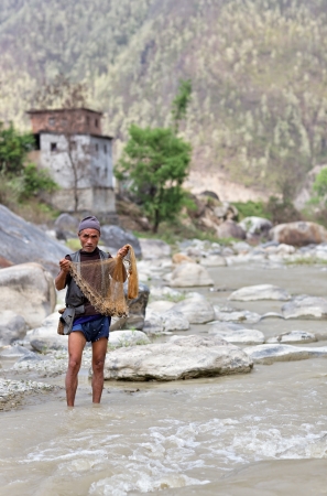 SALLAGHARI, NEPAL - APRIL 4  Portrait of unidentified Nepalese fisherman fishing on the bank of the river with traditional handmade fishing net April 4, 2009 in Sallaghari Village, Kathmandu, Nepal のeditorial素材