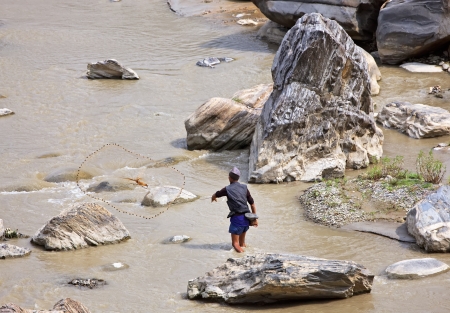 SALLAGHARI, NEPAL - APRIL 4  Portrait of unidentified Nepalese fisherman fishing on the bank of the river with traditional handmade fishing net April 4, 2009 in Sallaghari Village, Kathmandu, Nepal のeditorial素材