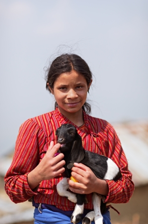 NAGARKOT, NEPAL - APRIL 5  Portrait of young unidentified Nepalese girl with a kid goat on April 5, 2009 in Nagarkot Village, Kathmandu, Central Region, Nepal のeditorial素材