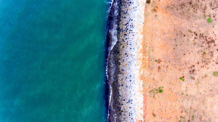Water crashing onto a beautifully textured rocky shore.の写真素材