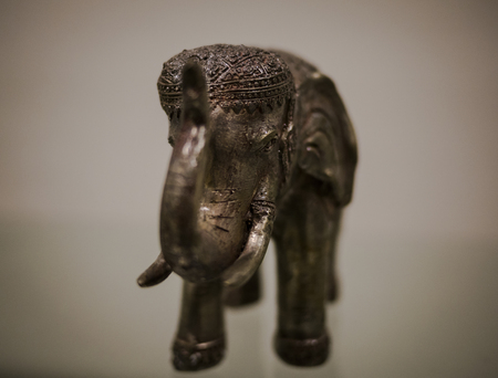Close up still life of beautiful carved metal elephant with a white backgroundの写真素材