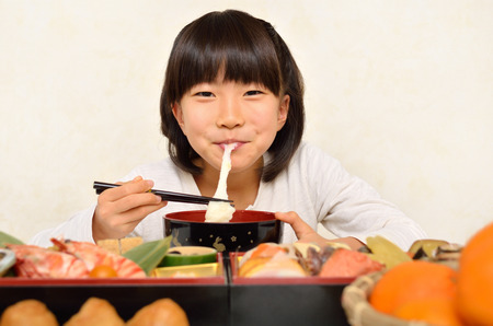 Girl eating a rice cake soupの写真素材