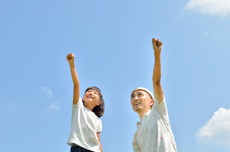 Parent-child raise their hands in the skyの写真素材