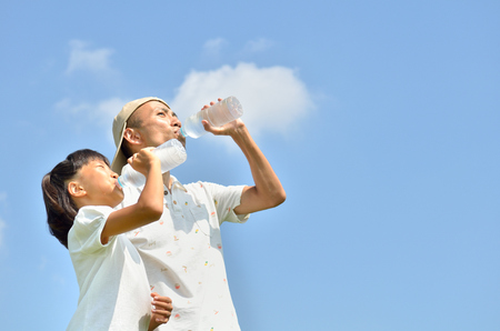 Parents and children to drink water in the blue skyの写真素材