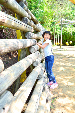 A girl playing at the playground in the Parkの写真素材