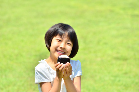Girl eating rice ballsの写真素材