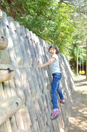 A girl playing at the playground in the Parkの写真素材