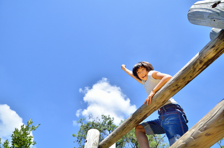 A girl playing at the playground in the Parkの写真素材