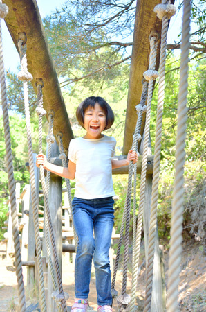 A girl playing at the playground in the Parkの写真素材