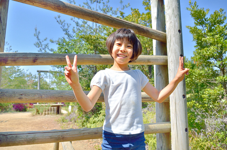 A girl playing at the playground in the Parkの写真素材