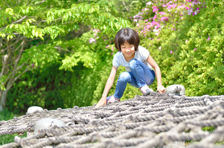 A girl playing at the playground in the Parkの写真素材